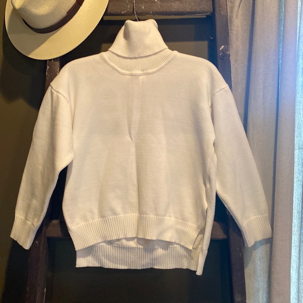 Never worn white turtleneck sweater. Queen is written on back in black. Small